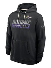 A black Nike Baltimore Ravens pullover hoodie featuring the team logo on the left chest, a large 'RAVENS' graphic with 'ENGINEERED FOR' underneath, and a white Nike swoosh on the right sleeve, shown against a light gray background.