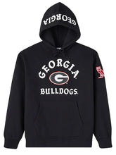 A black pullover hoodie featuring the Georgia Bulldogs logo on the front, with 'GEORGIA BULLDOGS' printed in white on the chest and hood, and a red owl logo on the sleeve.