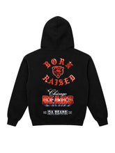 A black hoodie shown from the back, featuring a large Chicago Bears graphic with red and white text and a bear head logo on a light gray background.