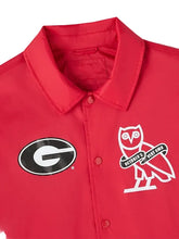 A close-up of a red button-front collared shirt jacket featuring a black-and-white Georgia 'G' logo on the left chest and a white owl graphic with 'October's Very Own' text on the right chest, shown against a light gray background.