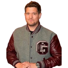 A man wearing a gray and burgundy varsity jacket with a large 'G' and 'OKLAHOTA 78' patch on the chest, posed against a dark studio background with blue lighting.
